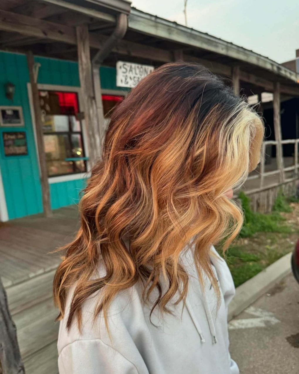 Medium-length wavy hair with a color gradient from dark to blonde for school