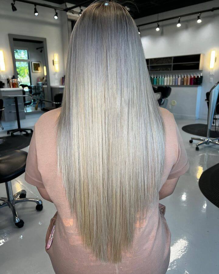 Silver ombrÃ© balayage on a layered V-cut for a trendy look.