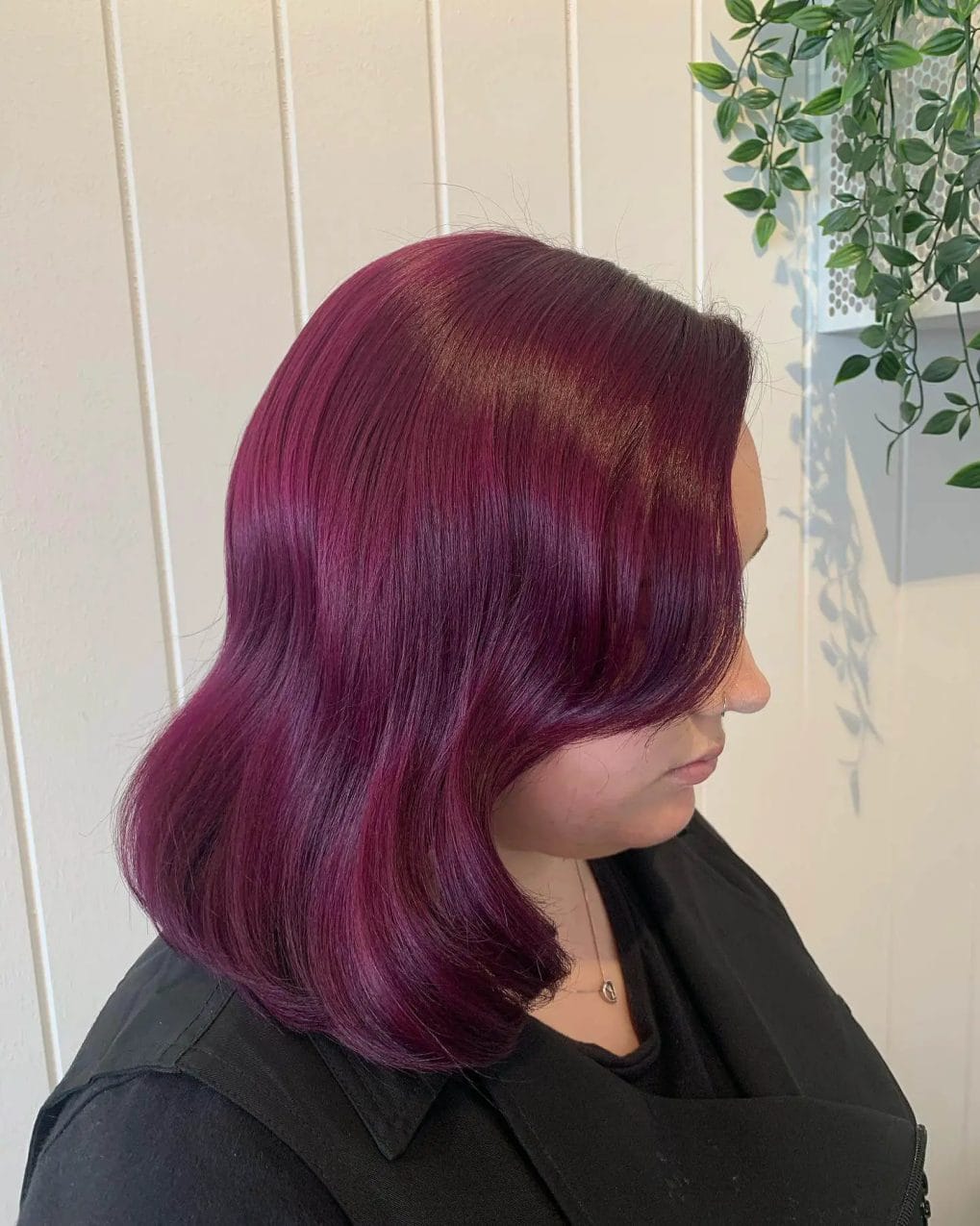 Berry-burgundy blend on a smooth shoulder-length cut with soft curves.