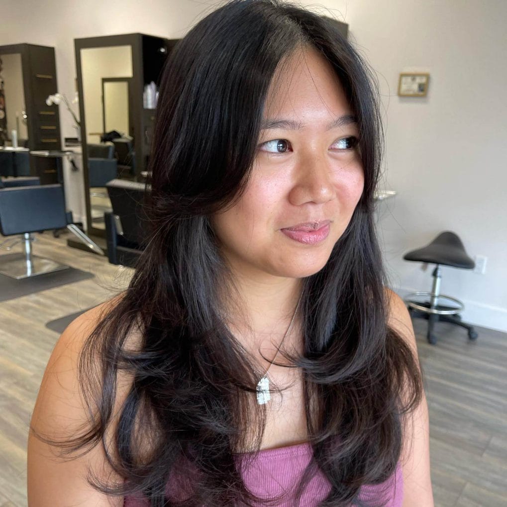 Lustrous black waves with middle-parted curtain bangs.