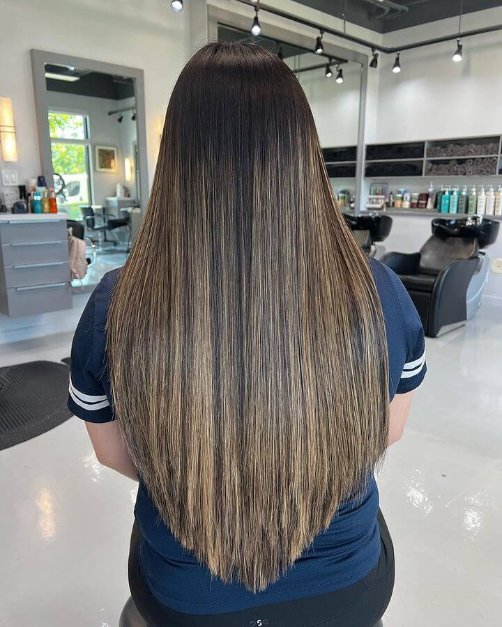 Long hair with blond balayage highlights and a V-cut layering.