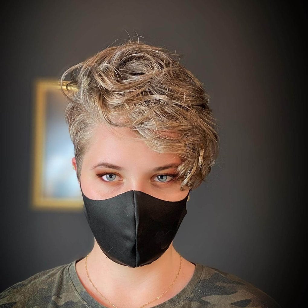 Sun-kissed wavy blonde pixie with an extended fringe.