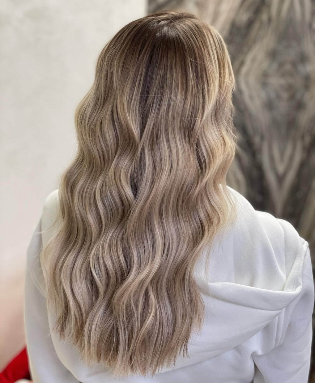 Long hairstyle with cool and warm blonde balayage, perfect for adding winter dimension.