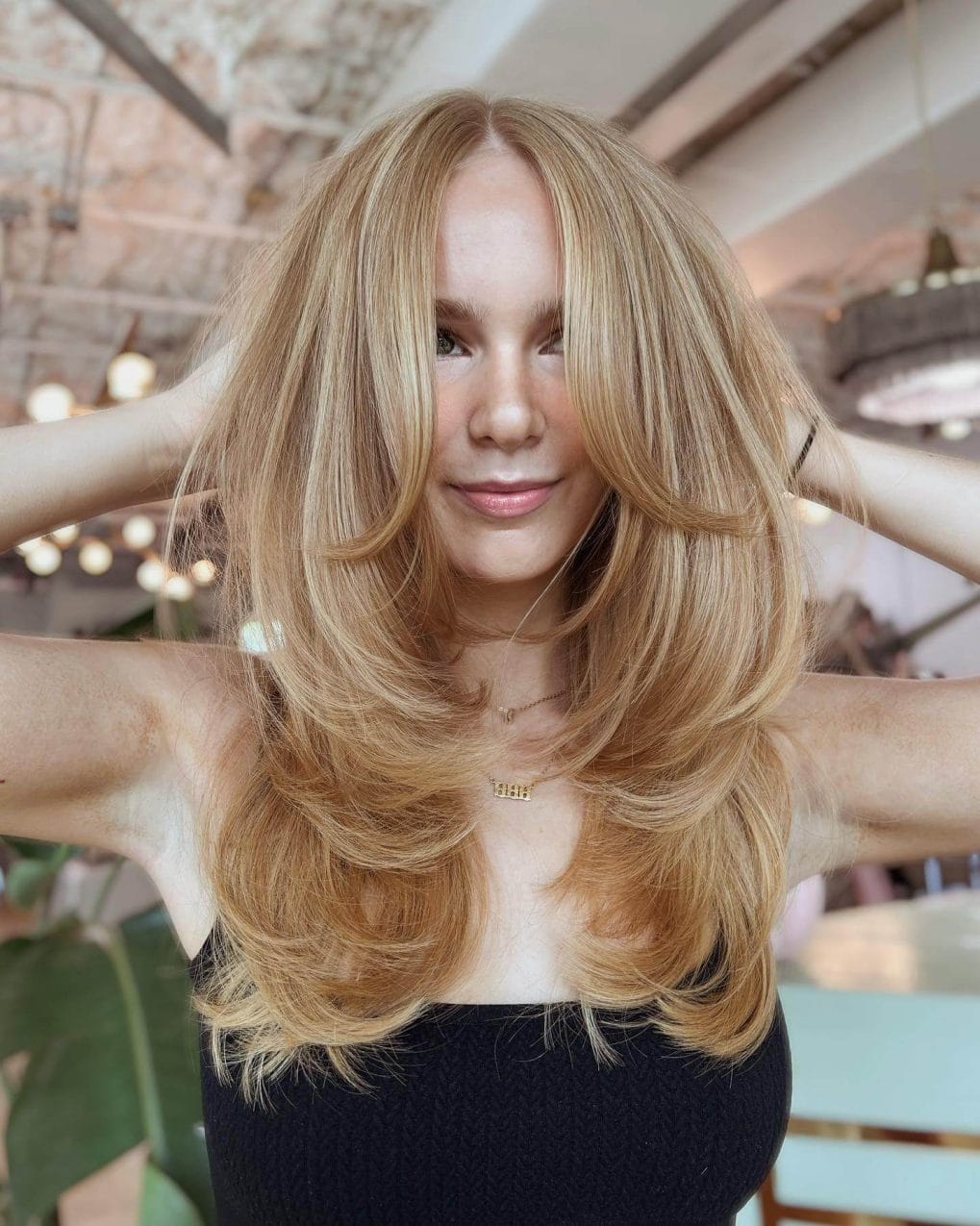Blonde hair with 90's contour and long layers in a voluminous blowout.