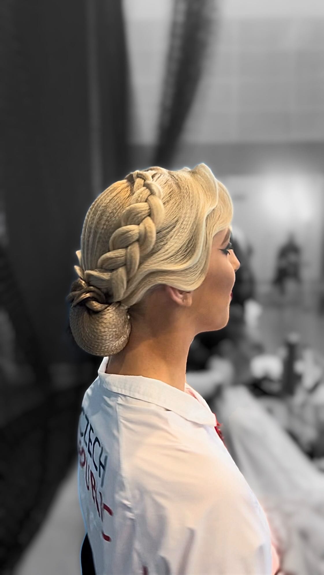 Blonde braid crowning into a tidy bun for dance precision