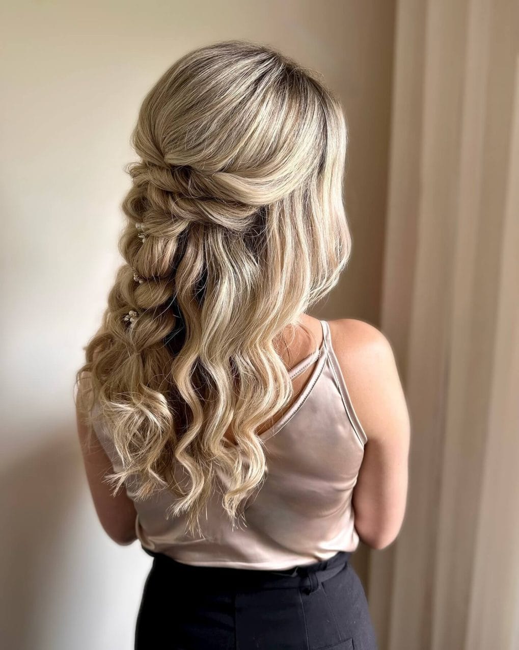 Elegant blonde half-up braid transitions into soft curls