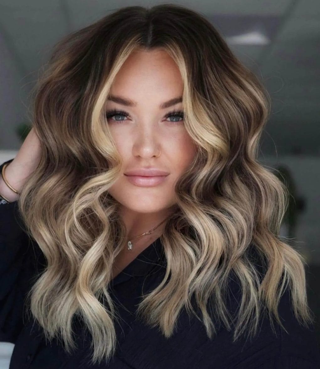 Blonde highlighted lob with beachy waves and dark roots
