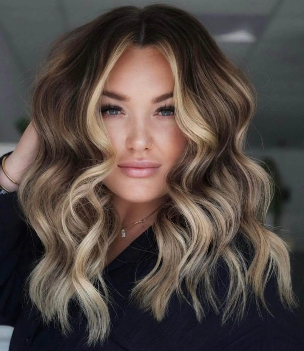 Blonde highlighted lob with beachy waves and dark roots