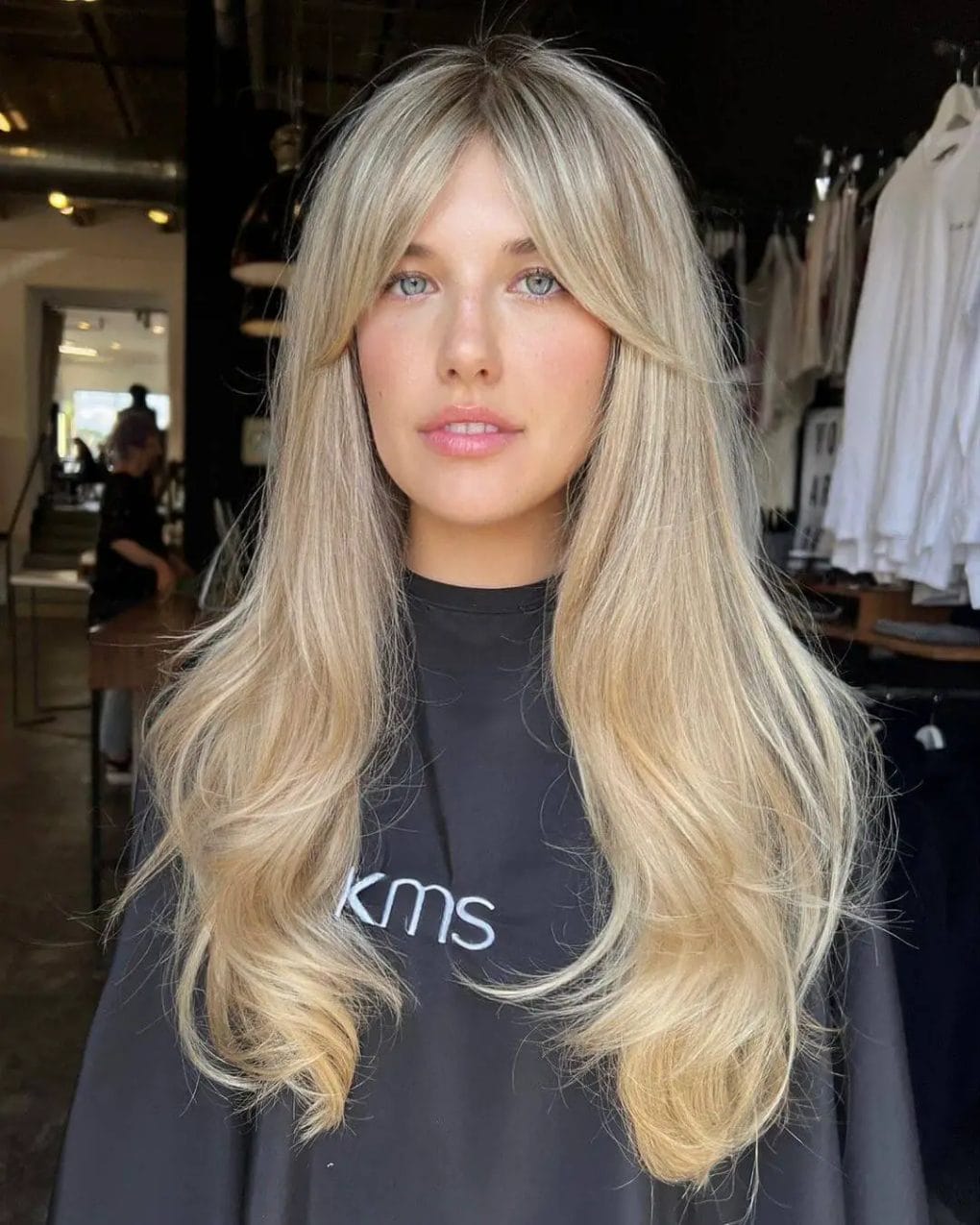 Sun-kissed blonde layers with soft middle-parted curtain bangs, capturing modern elegance.