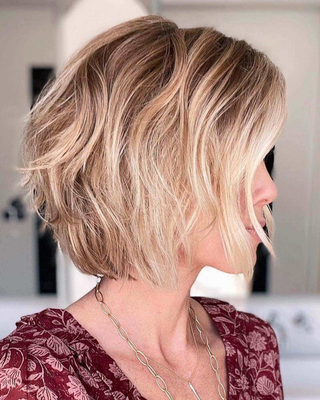 Modern blonde highlighted textured bob with a tousled, edgy look.