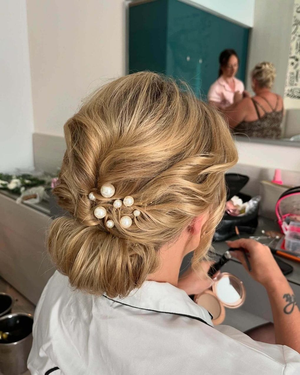 Blonde waves in a chic low updo with pearl pins.