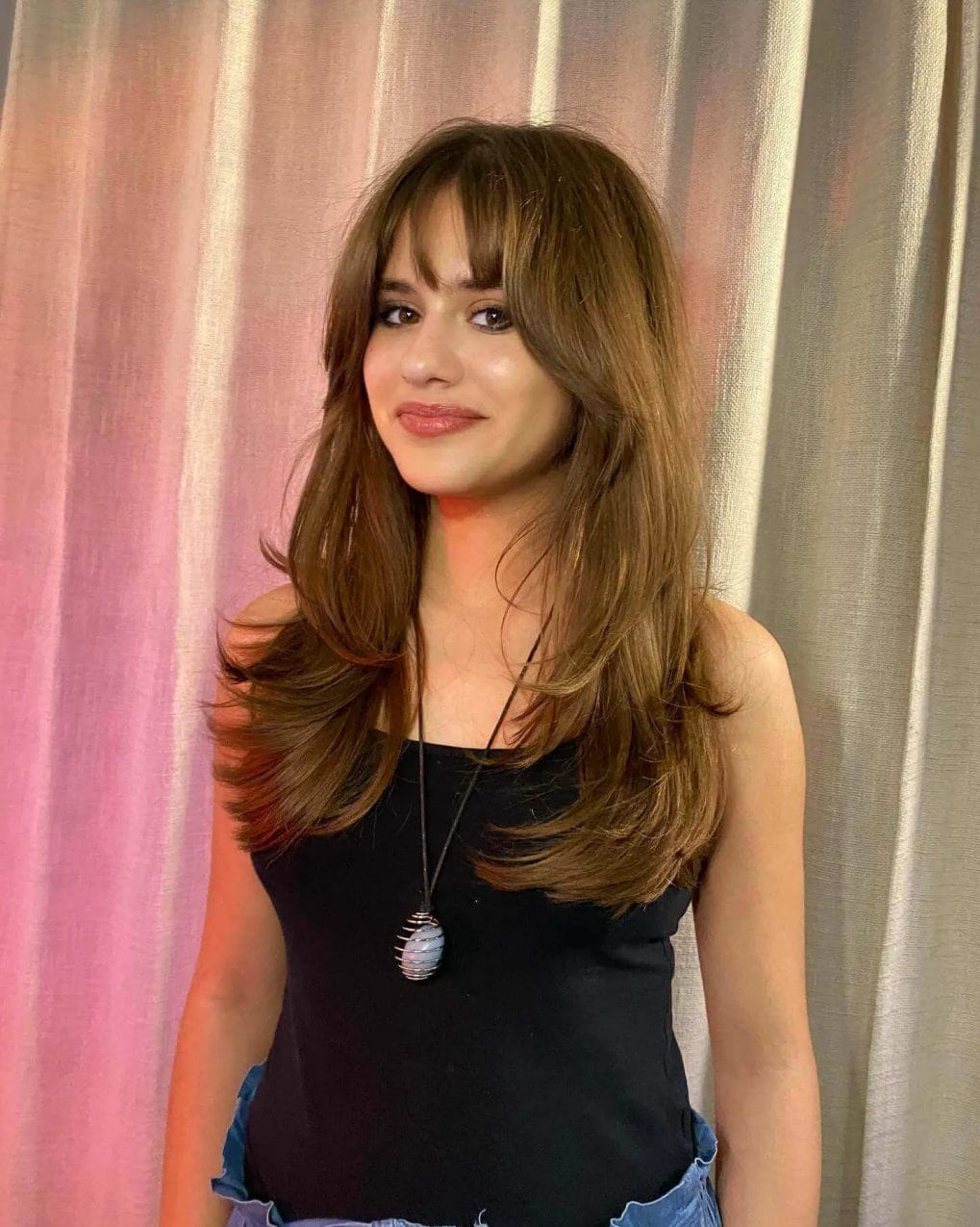 Smooth chestnut blowout with wispy modern bangs great for round faces.