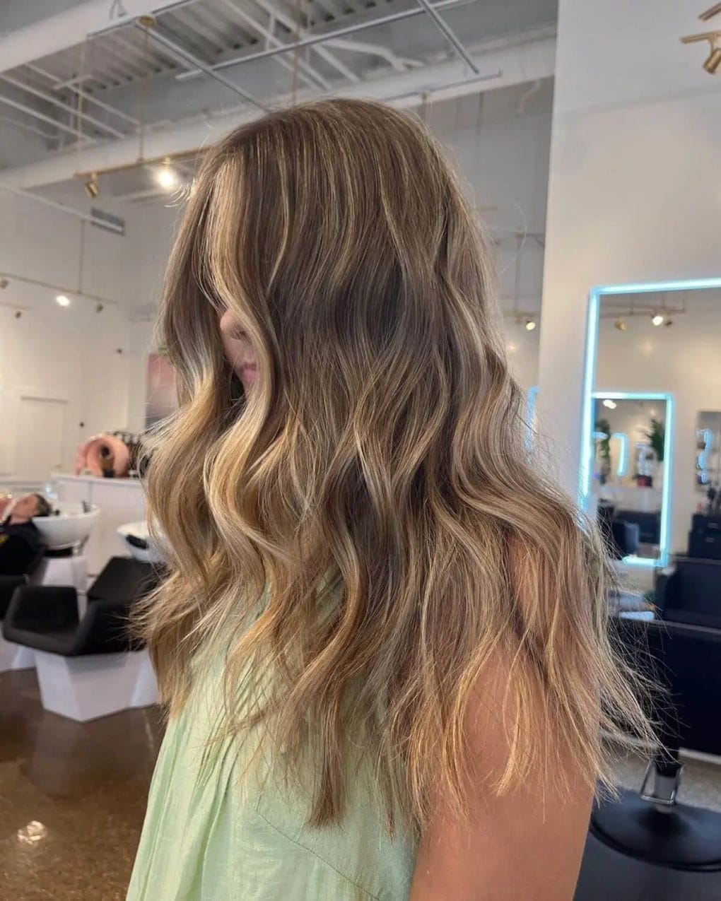 Bohemian waves with golden blonde gradient on brunette hair.