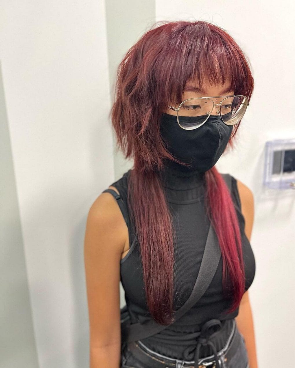 Bold burgundy jellyfish haircut with sleek texture, modern full fringe, and a striking silhouette.