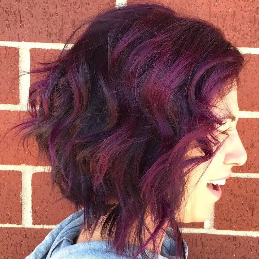 Bold purple-toned layered bob with enhanced natural curls.