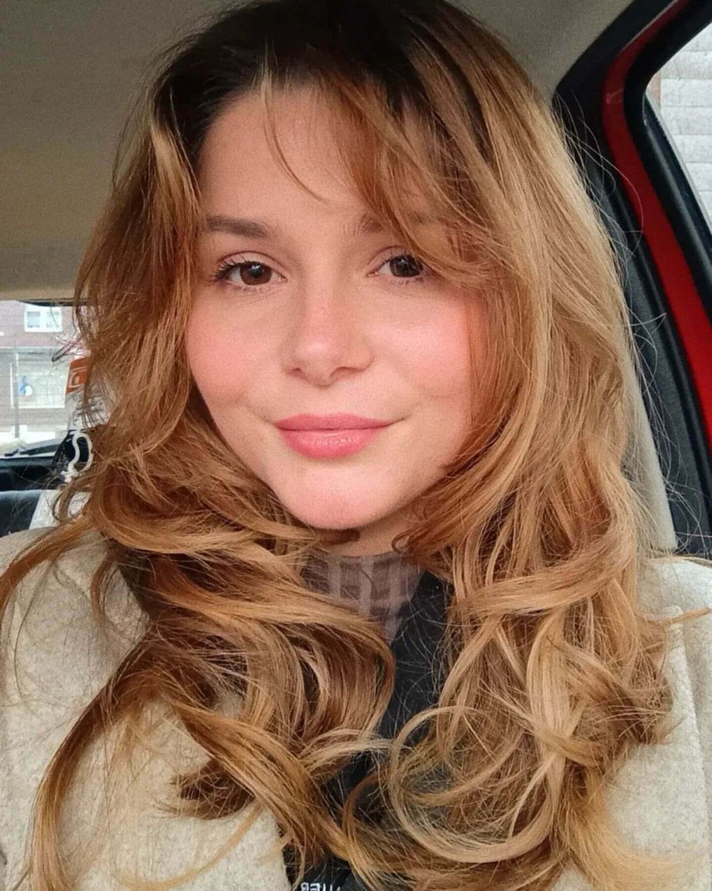 Bouncy golden-brown curls with wispy 90s bangs