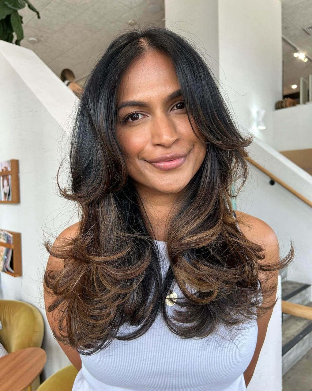Bouncy layered curls with 90s curtain bangs