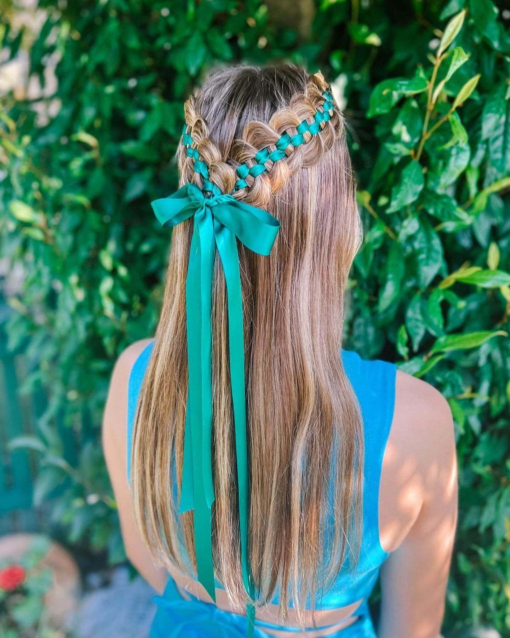 Braids with teal ribbon creating a crown effect.