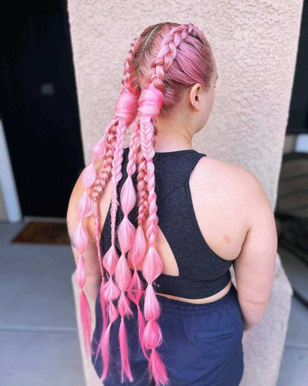 Bright pink thick braids starting from neat cornrows with fluffy ends