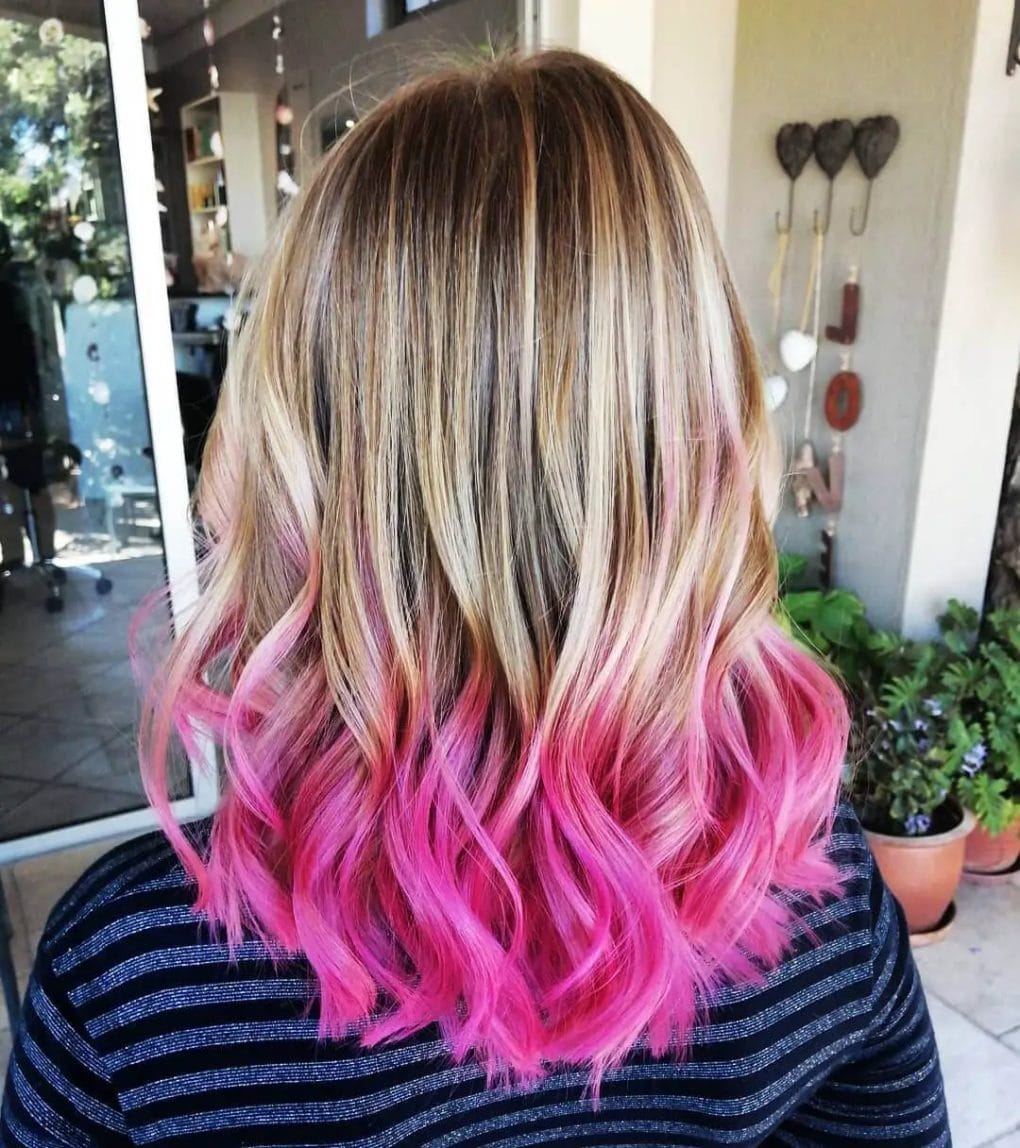 U-shaped cut combining brunette with audacious pink balayage and soft wavy layers.