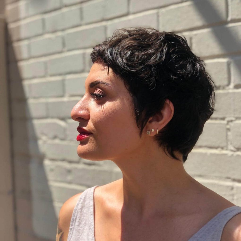 Deep raven wavy pixie with side-swept fringe.