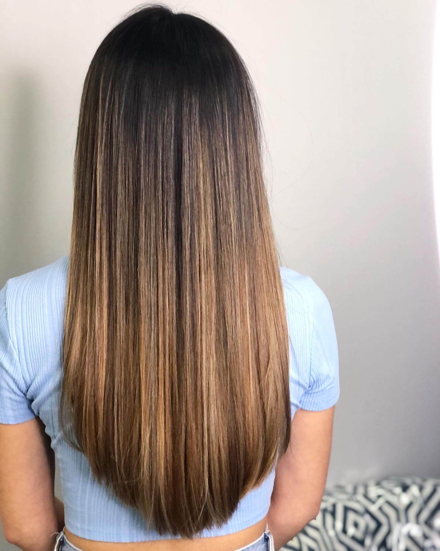 U-shaped flow transitioning from brunette roots to a caramel balayage.