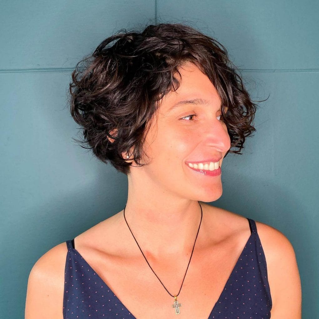 Voluminous brunette pixie with a side fringe.