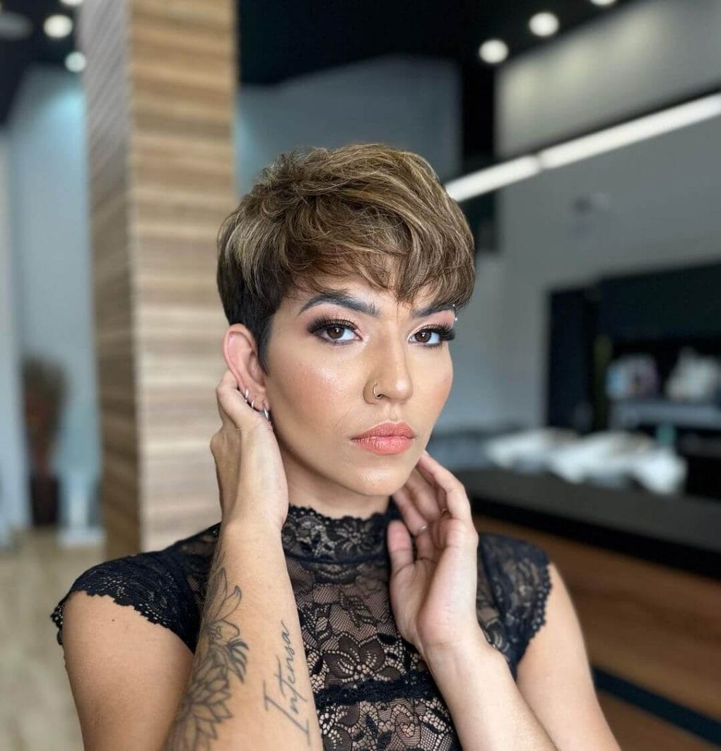 Brunette wavy pixie with blonde streaks and an elegant front bang.