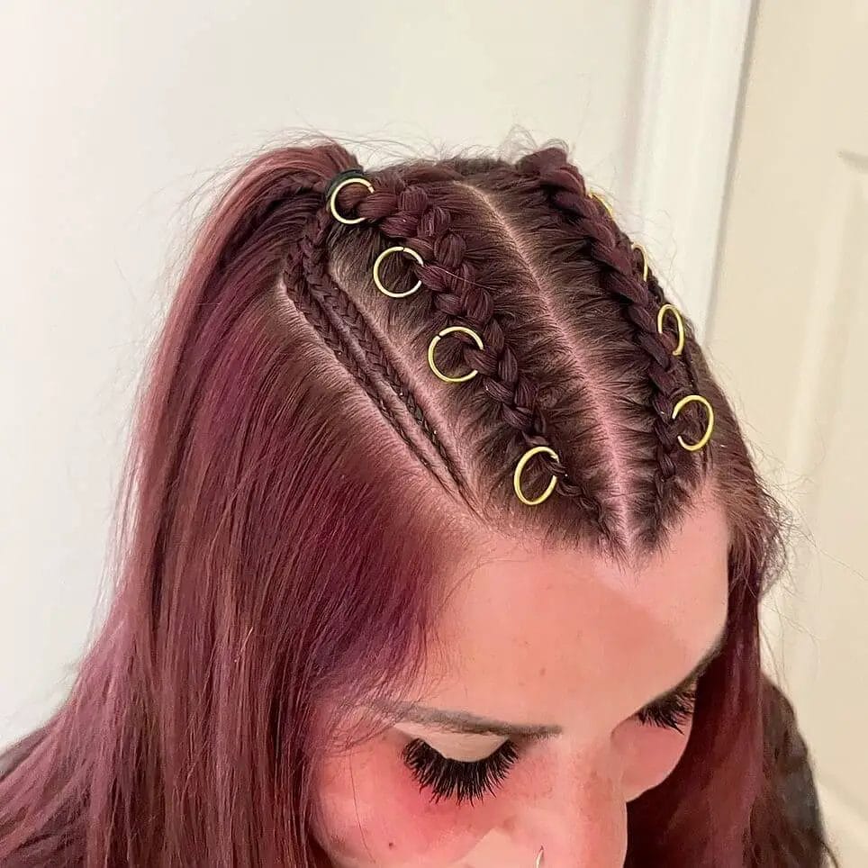 Sleek burgundy cornrows adorned with chic gold rings