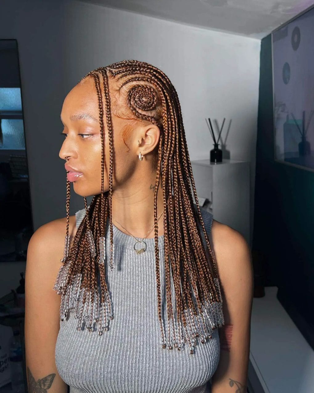 Intricate caramel-toned braids in a spiral pattern with shimmering silver beads.