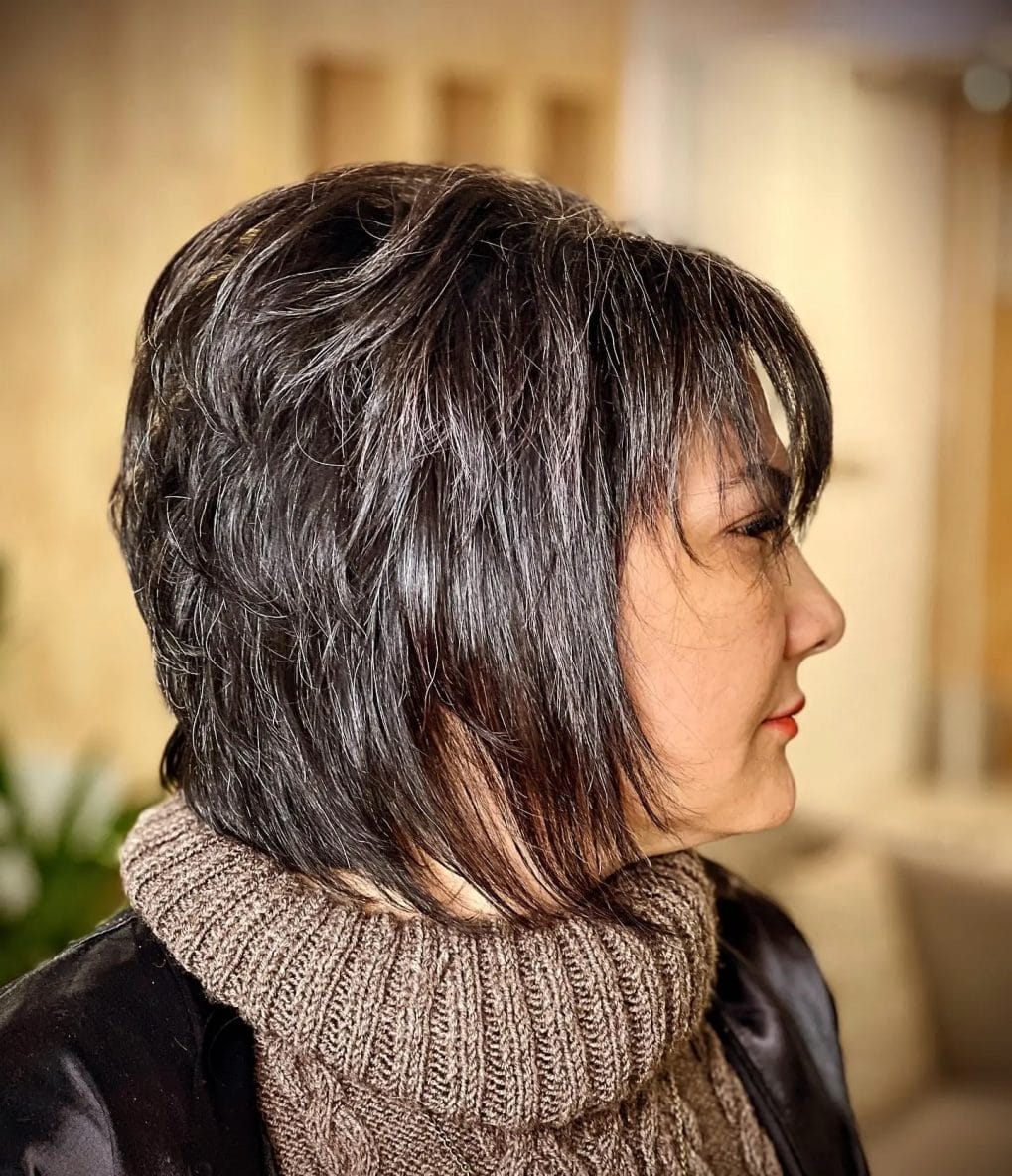 Natural dark tousled pixie bob with lengthier strands at the front framing the face
