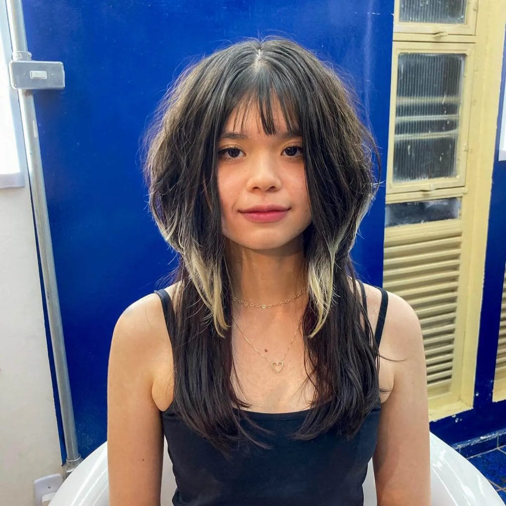 Tousled, layered jellyfish haircut with a playful fringed bang and subtle highlights.