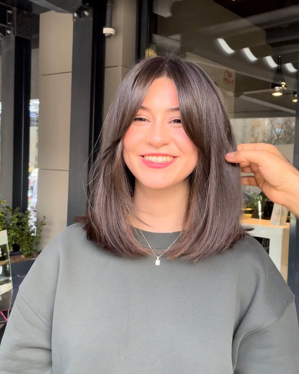 Sleek charcoal grey shoulder-length bob with full curtain bangs.