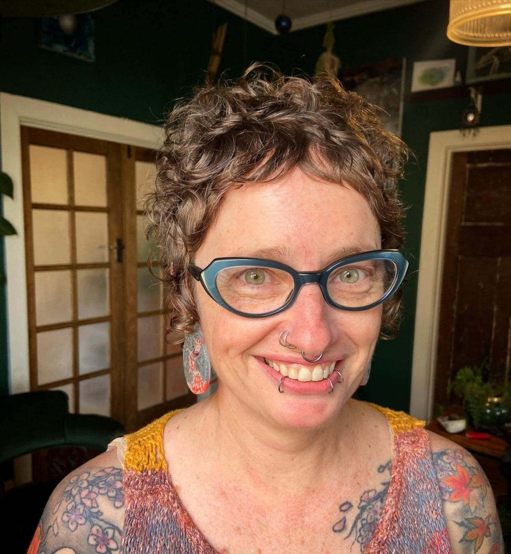 Charming salt-and-pepper curly pixie with soft fringe.