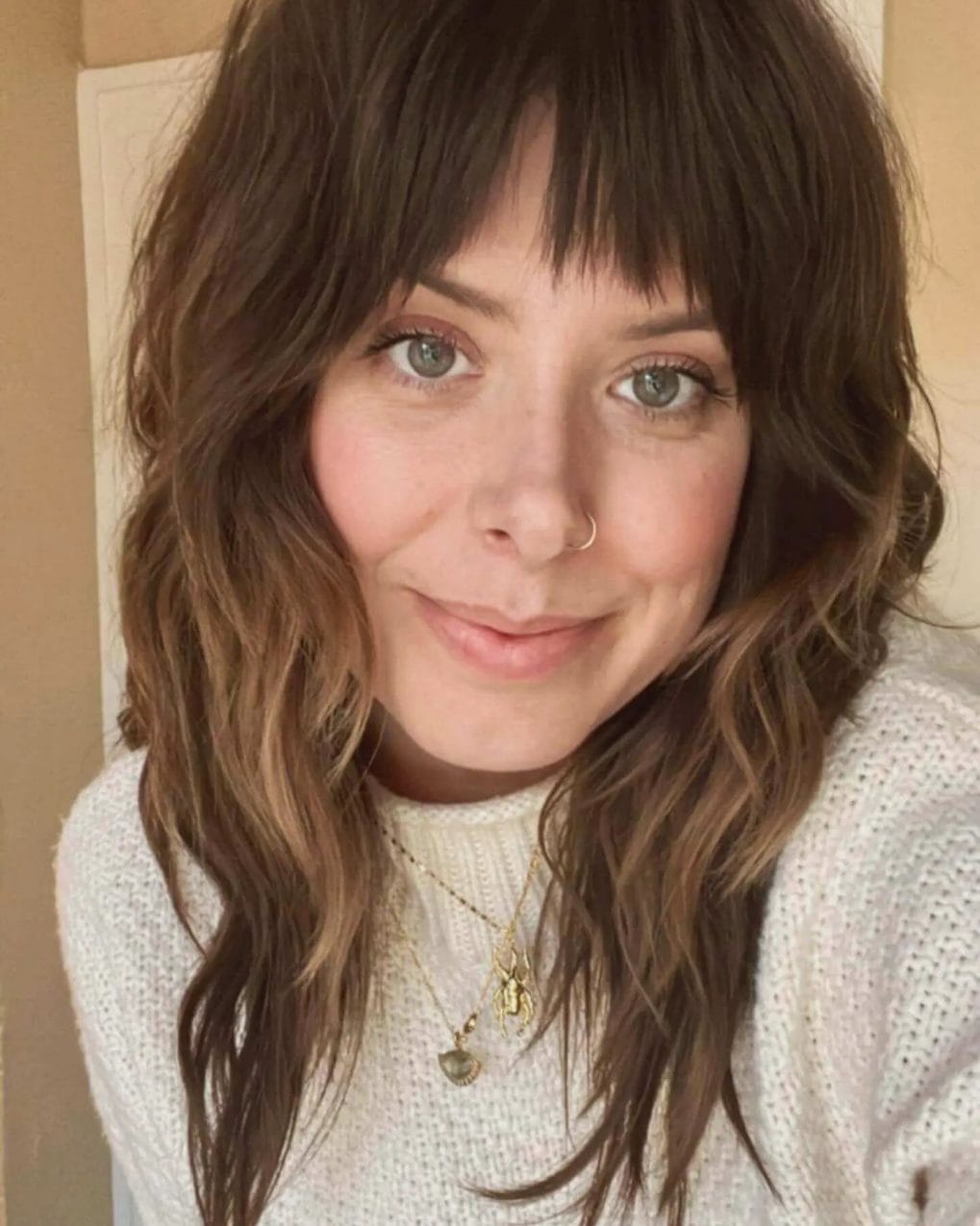 Chestnut balayage waves with choppy, textured bangs