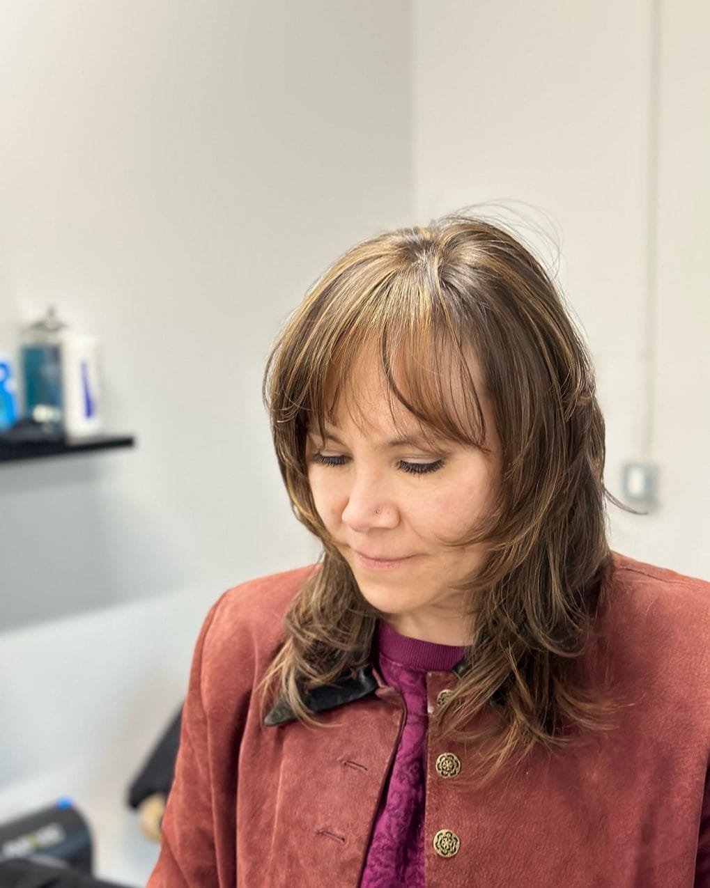 Medium-length hair blending chestnut and golden highlights with a youthful fringe.