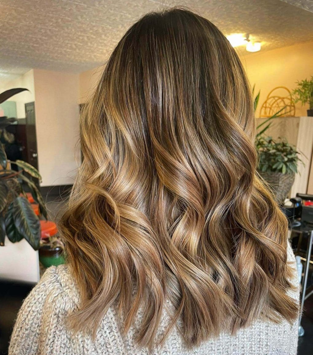 Flowing layers in a chestnut to golden wheat balayage, mirroring winter's early dawn.