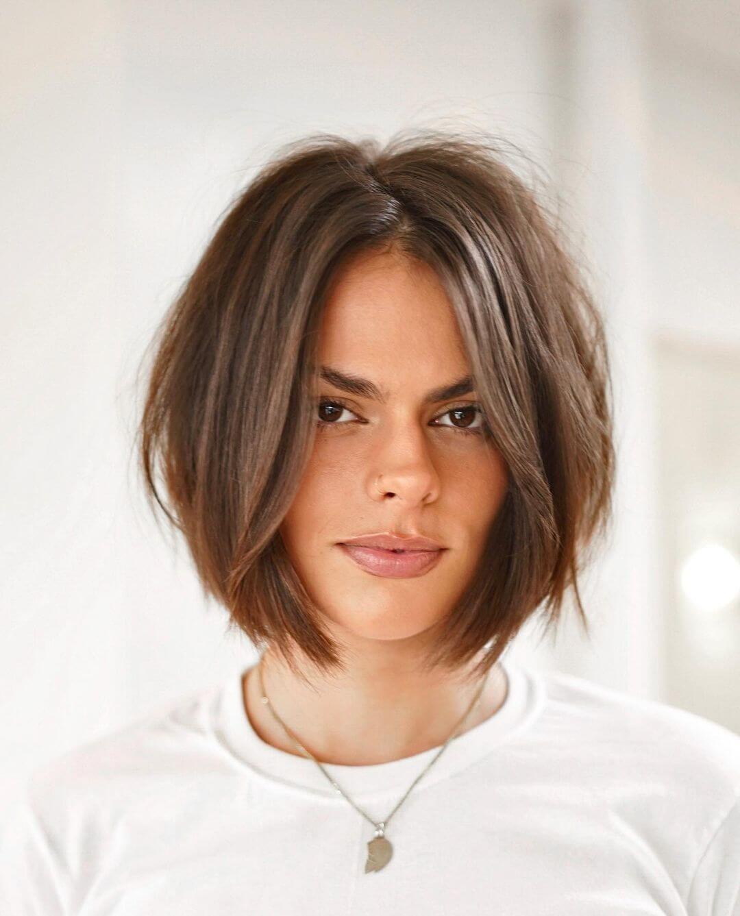 Effortlessly chic textured bob with cool-toned brown and light feathering.