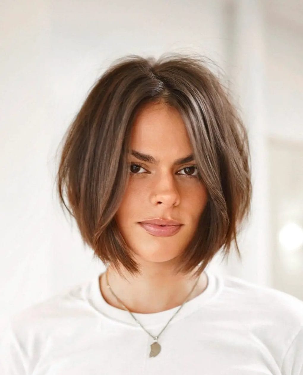 Effortlessly chic textured bob with cool-toned brown and light feathering.