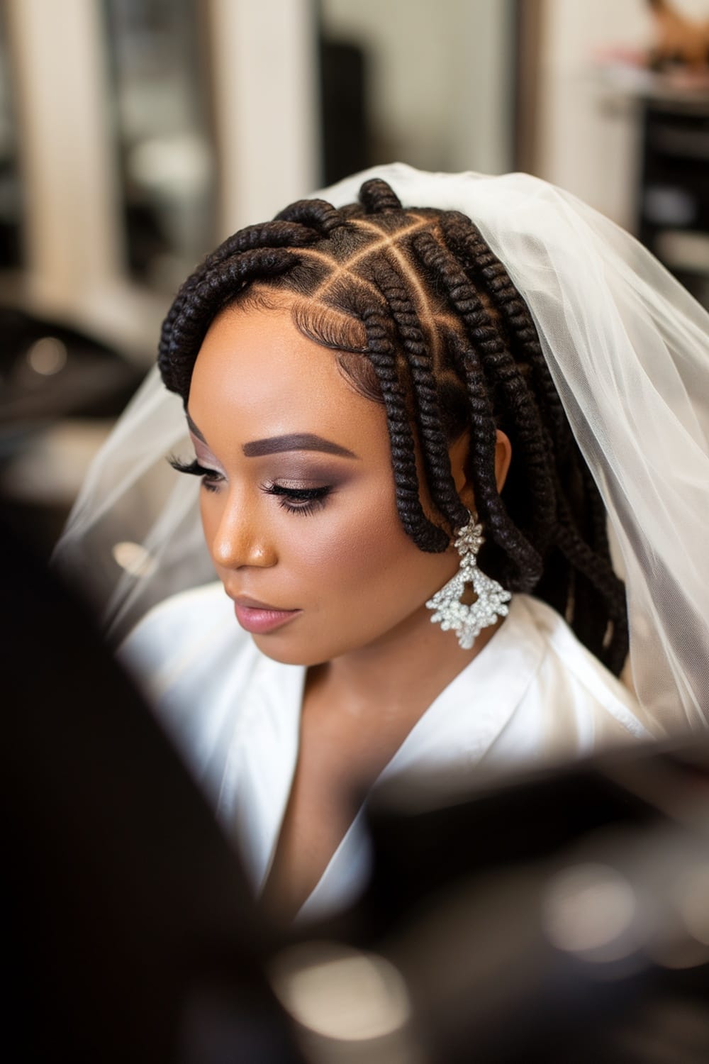 A bride with chic Bantu knots, wearing elegant earrings and a veil, showcasing a sophisticated wedding hairstyle.