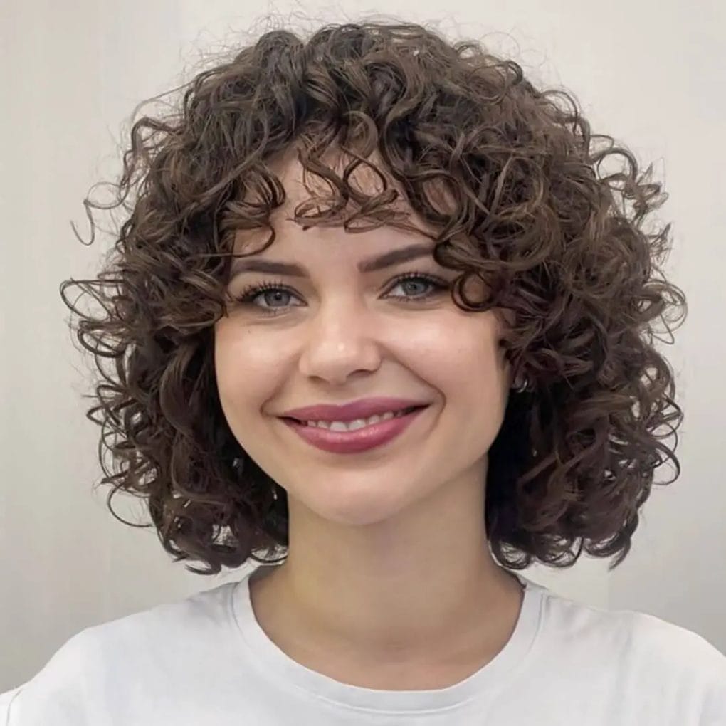 Chin-length bob with soft, defined curls framing the face.