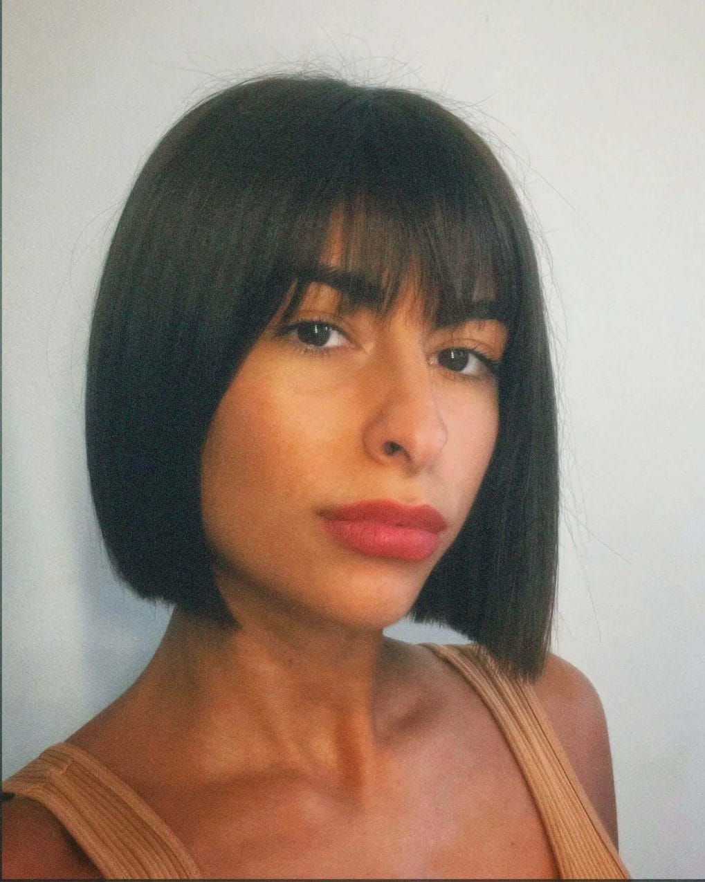 Sharp chin-length '90s bob in dark color with a full fringe