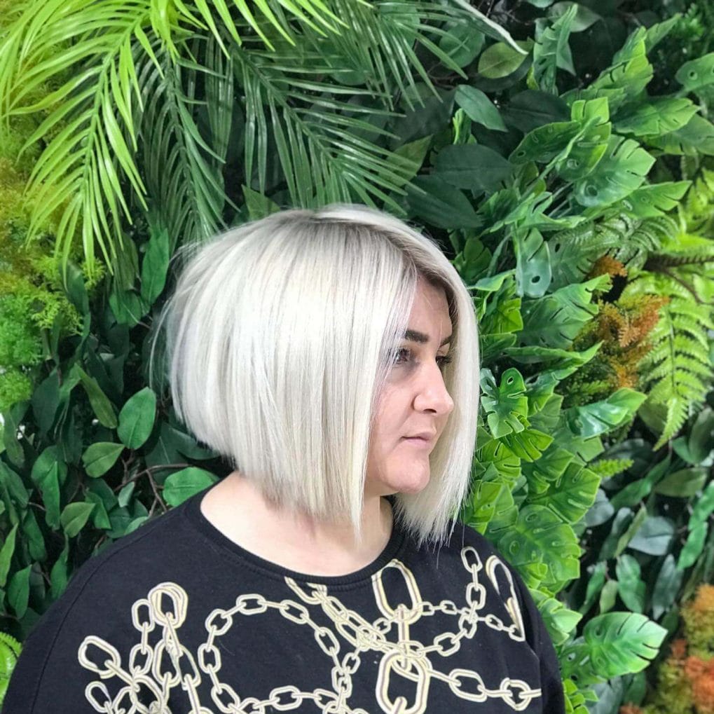 Sleek chin-length bob in platinum with elegant curtain bangs.