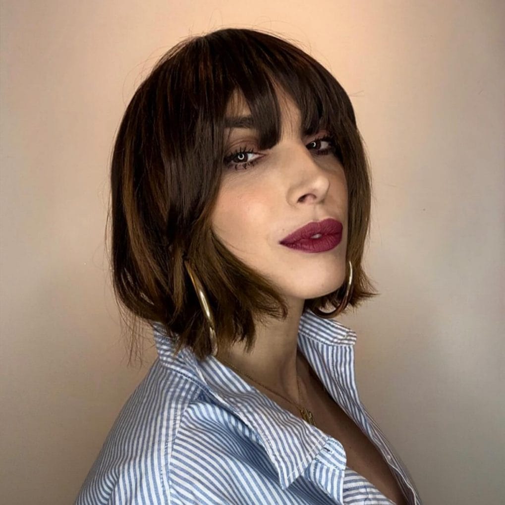 Chin-length trendy bob with full bangs in dark chocolate hue