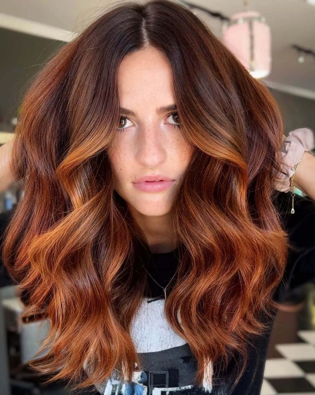 Chocolate roots melting into vivid copper waves with layered face framing.