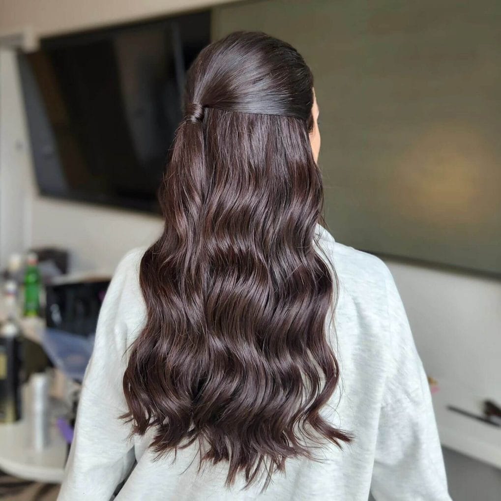 Half-up style holding long chocolate-colored waves back for softball clarity