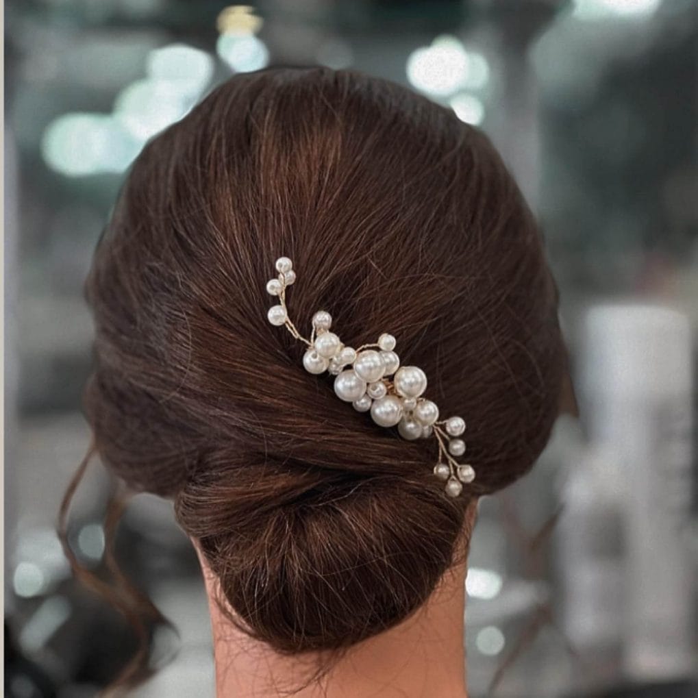 Classic chignon with a delicate pearl hairpin.