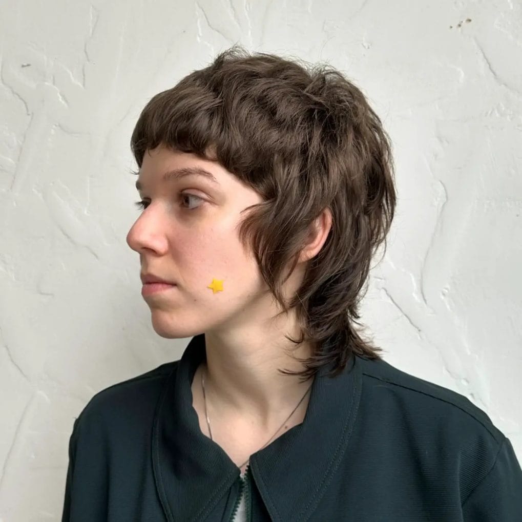 Classic short shaggy mullet with tousled straight-across bangs in dark brown
