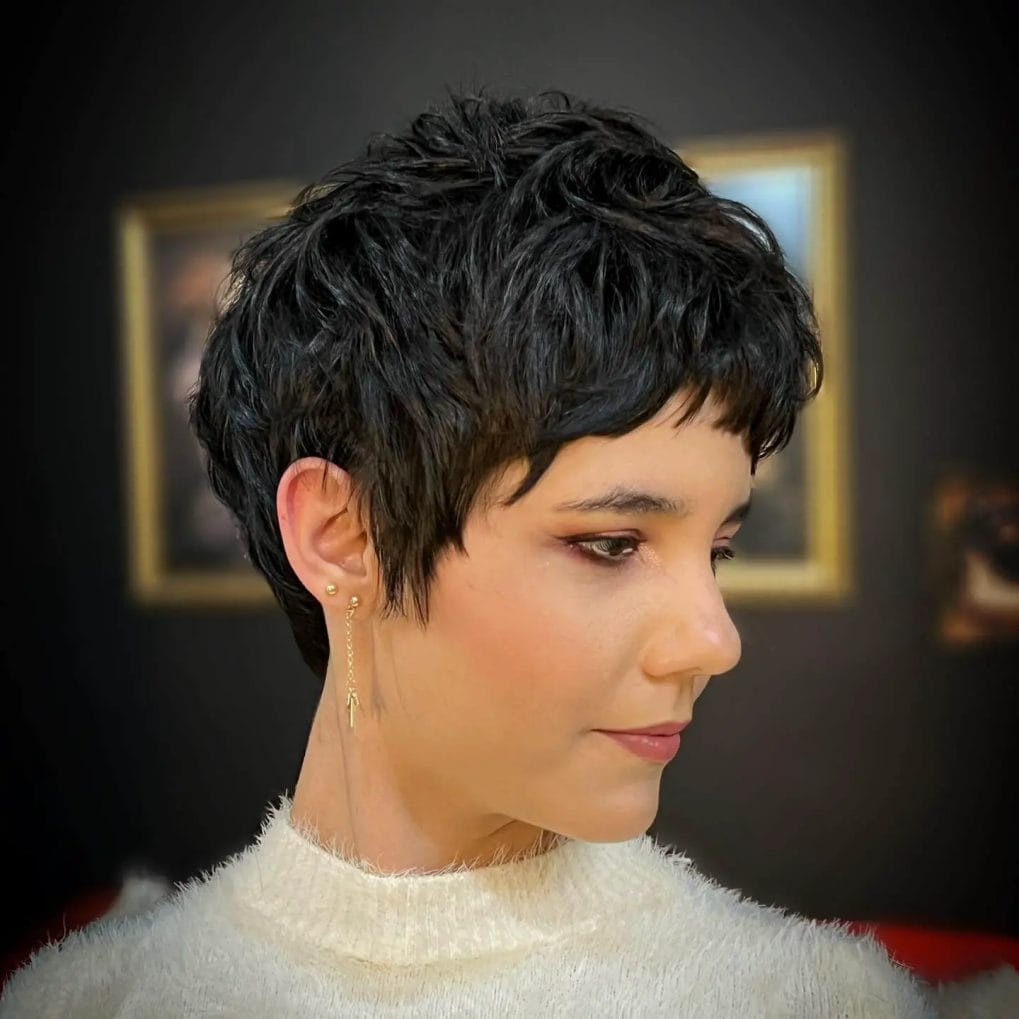 Timeless wavy black pixie with edgy sideburns.