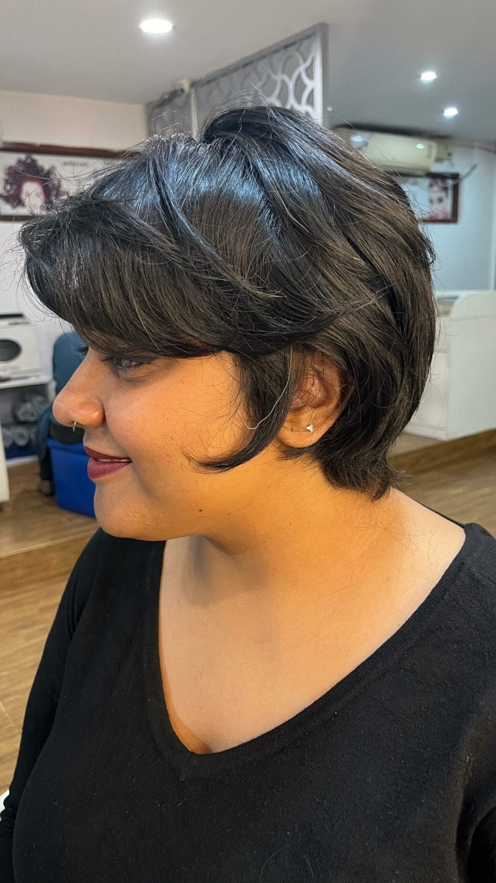 Bold jet-black short pixie bob with a neat undercut and full straight-across bangs
